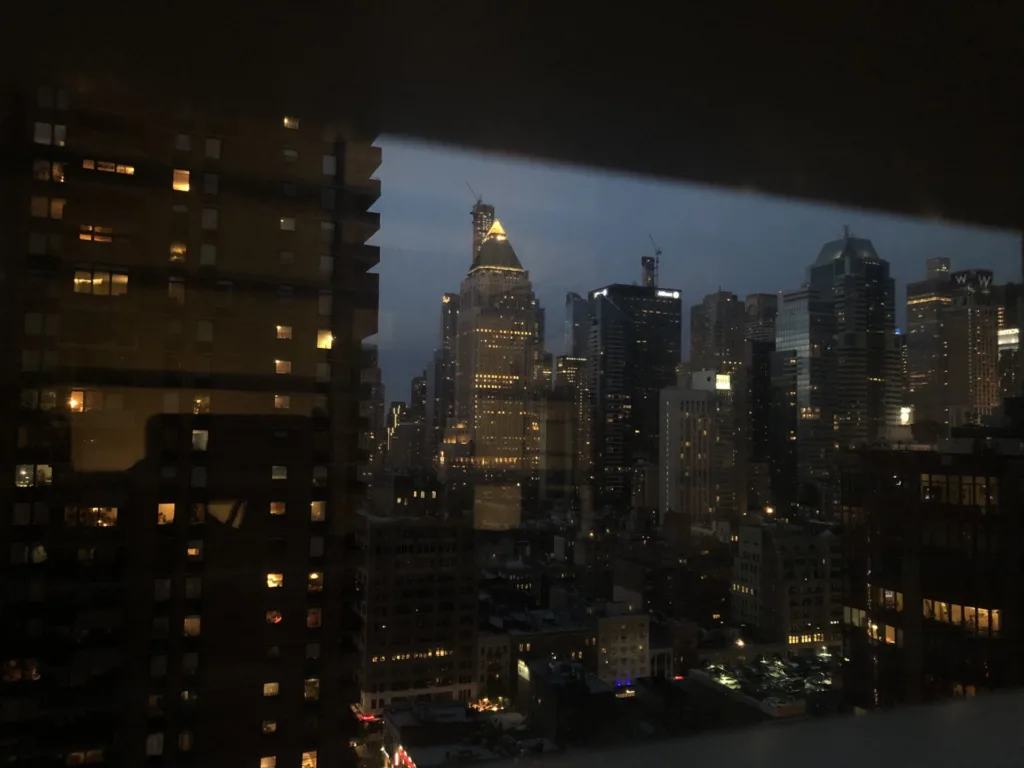 Blick aus dem Fenster in Manhattan, New York - In der Dämmerung leuchten unzählige Fenster der umliegenden Gebäude.
